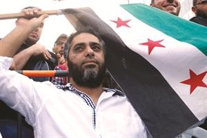 الفنان فضل شاكر يرفع علم الثورة السوري في مظاهرة نظمها الشيخ احمد الاسير في صيدا	رويترز﻿