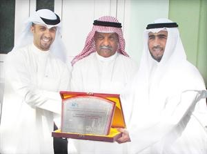 علي البغلي يتسلم درعا تذكارية من مدير المدرسة
