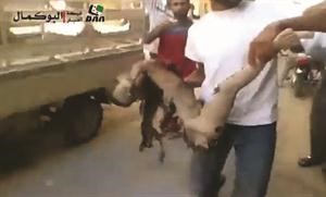 صورة بثتها صفحة الثورة السورية لرجل يحمل اشلاء طفل قتل في قصف طيران النظام على مدينة البوكمال