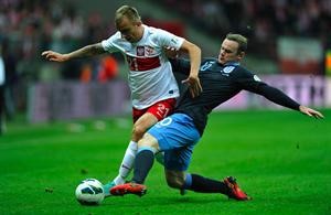 مهاجم انجلترا واين روني يحاول قطع الكرة من المدافع الپولندي كاميل غليك افپ