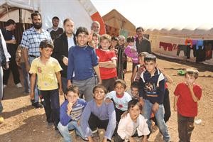 بدر بورحمه متوسطا جمال النوري وفيصل الياقوت مع عدد من الاطفال في مخيم اطمة الحدودي