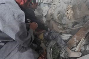 سوريون يسحبون جثة طفل من تحت الانقاض افپ