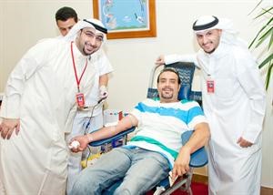 موظفو بنك الخليج مع احد العملاء اثناء تبرعه بالدم
