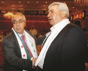 رئيس المجلس الوطني عبدالباسط سيدا مصافحا المعارض رياض سيف رويترز