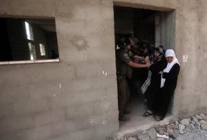 فلسطينية تقاوم جنودا اسرائيليين يحاولون اخراجها من منزلها بعد ان هدموه في قرية حارس بالقرب من نابلس بالضفة الغربية امس الاول	افپ﻿