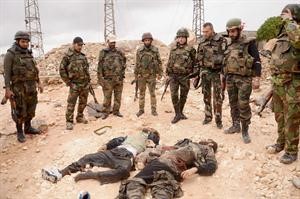 مجموعة من الجيش السوري ينظرون الى قتيلين من الجيش الحر في شارع الشيخ سعد في حلب رويترز
