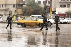 رجال امن عراقيون يؤمنون الطرقات في بغداد بعد عواصف شديدة 	افپ﻿