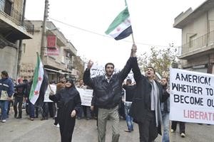 متظاهرون يرفعون اعلام الثورة السورية في مدينة كفرنبلرويترز