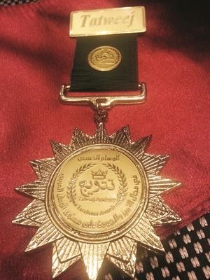 الوشاح الاحمر الارجواني مع وسام الاستحقاق الذهبي