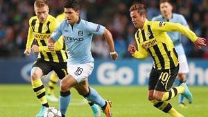 مهاجم مان سيتي سيرجيو اغويرو يمر من لاعبي بوروسيا دورتموند في مباراة الذهاب بالدور الاول