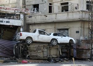 سيارات مدمرة يستخدمها سكان حي كرم شمشم في حمص للوقاية من قناصي النظام السوري رويترز