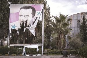 احد مقاتلي الجيش الحر يصلي بجانب صورة ممزقة للرئيس بشار الاسد في حلب اپ