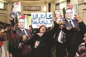 مؤيدون للرئيس السابق يرفعون صوره خارج قاعة المحكمة امس رويترز