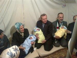 اردوغان يتوسط زوجته ومعاذ الخطيب في احد المخيمات حاملين 3 توائم انجبتهم سورية واطلقت عليهم اسماء رجب وطيب واردوغان بحسب مواقع التواصل