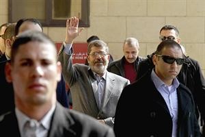 الرئيس المصري د محمد مرسي يحيي مؤيديه عقب صلاة الجمعة في القاهرة امس 	رويترز﻿