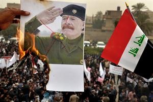 محتجون يضرمون النار في صورة لعزة الدوري في تظاهرة مؤيدة لنوري المالكي بالبصرة امس	اپ﻿
