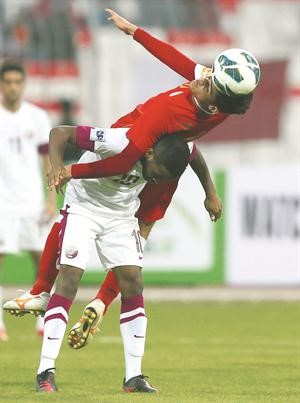 لاعب عمان عبدالعزيز مبارك يبعد الكرة من امام مهاجم قطر خلفان ابراهيم افپ 