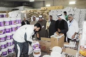 اعضاء فريق مراقبة الاغذية يعاينون المواد في احد المخازن﻿