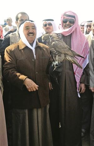 صاحب السمو الامير يحمل احد الصقور بحضور الشيخ احمد الفهد
