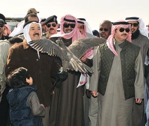 صاحب السمو الامير يحمل احد الصقور ويبدو الشيخ احمد الفهد والشيخ خالد العبدالله