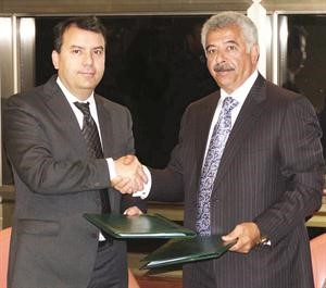 نجيب الصالح وانس العلمي يتصافحان عقب توقيع مذكرة التفاهم﻿