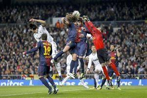 مدافع برشلونة جيرار بيكيه يبعد الكرة براسه وسط زحمة لاعبين اپ
