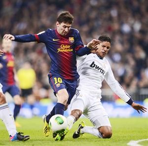 ليونيل ميسي يتعرض للمضايقة من مدافع ريال مدريد رافايل فاران افپ
