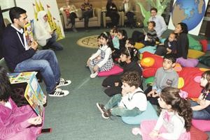 احد المتطوعين يقرا قصة للاطفال﻿