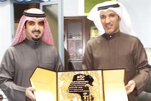 الشيخ تركي اليوسف يتسلم درعا من مبارك عبدالعزيز﻿