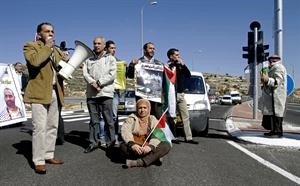 فلسطينيون يغلقون احد طرق الضفة تضامنا معع الاسرى في سجون الاحتلال	 اپ﻿