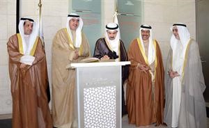 الراشد يدون كلمة في سجل الزيارات في متحف قطر الاسلامي بجواره اعضاء الوفد