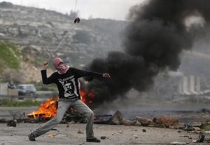 فتى فلسطيني يرمي قوات الاحتلال بالحجارة خلال مواجهات في رام الله امس رويترز