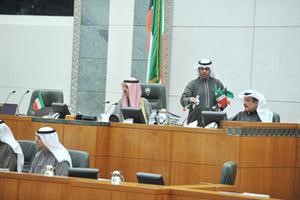 الرئيس علي الراشد وامين السر كامل العوضي على المنصة اثناء توزيع علم الكويت على القاعة
