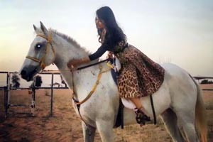 بالصور.. لجين عمران ترتدي " البرقع " وتركب الخيل