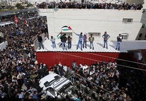 الاف الفلسطينيين خلال مشاركتهم في تشييع الاسير عرفات جرادات امس رويترز
