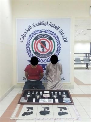 المتهمان وامامها المضبوطات 
