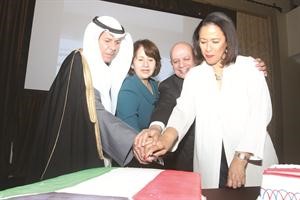 القنصل عبداللطيف اليحيا خلال قطع كيكة الاحتفال مع بعض الحضور﻿