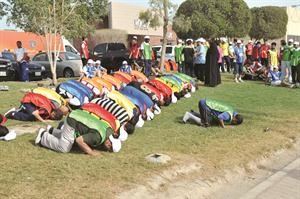 عدد من المتسابقين يؤدون الصلاة قبيل انطلاق الماراثون﻿