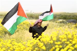 ناشط يحمل العلم الفلسطيني خلال مسيرة لاحياء يوم الارض في بيت حانون بالضفة الغربية امس	ا ف پ﻿