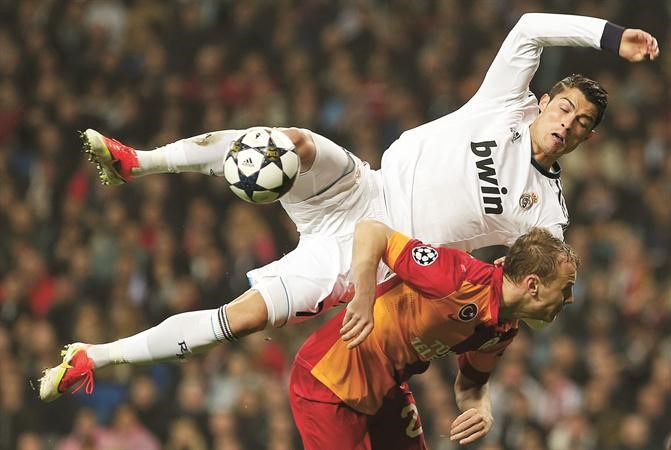 نجم ريال مدريد كريستيانو رونالدو يسقط على مدافع غلطة سراي سميح كايا رويترز