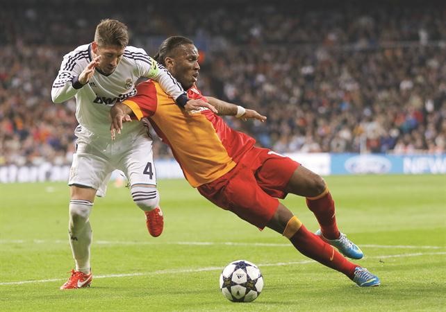 مدافع ريال مدريد سيرجيو راموس يستغل سقوط مهاجم غلطه ديدييه دروغبا ويمر بالكرة افپ