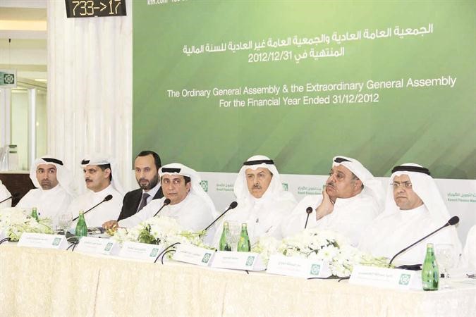  محمد علي الخضيري متوسطا الجمعية العمومية لـ بيتك وبجانبه محمد العمر 