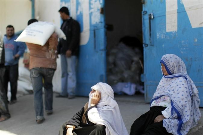 فلسطينيون ينتظرون امام مقر الاونروا بغزةلتسلم المساعدات الغذائية امس	افپ﻿