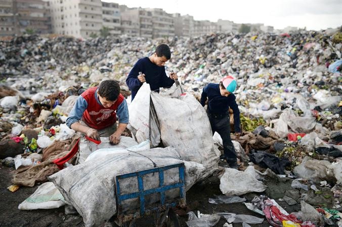 اطفال سوريون يجمعون مخلفات بلاستيكية يمكن الاستفادة منها من احد مكبات القمامة في حلب امسافپ

