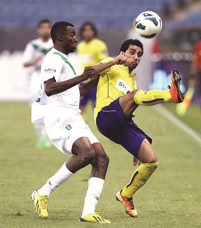 لاعب النصر حسن الراهب يبعد الكرة قبل وصول مدافع الاهلي اسامة هوساوي موقع النصر