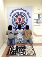 المتهمون وامامهم المخدرات المضبوطة ﻿