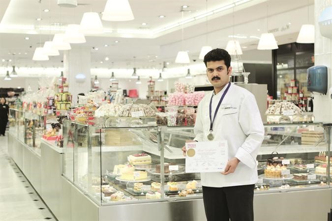 احد طهاة DeanDeluca حاملا شهادة الفوز بميدالية مهارات الطبخ الاستثنائية