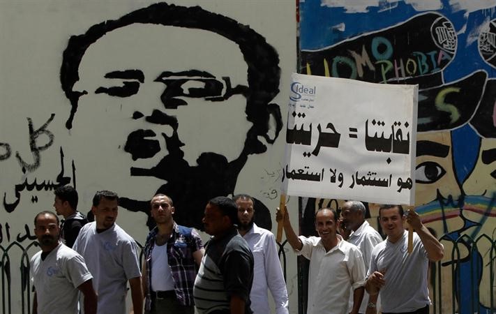 نقابيون عماليون يرفعون لافتات قرب ميدان التحرير امس تؤكد استقلالية نقابتهم عن الجدل السياسي بالبلاد	 رويترز﻿