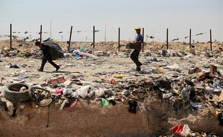  عراقيان يجمعان القمامة تمهيدا لاعادة تدويرها في احدالمصانع بالقرب منالنجف	رويترز﻿