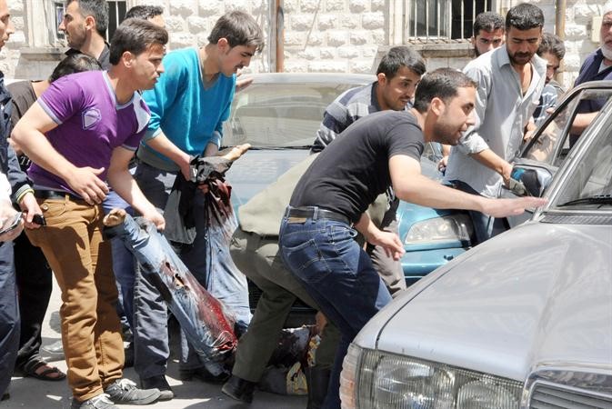 صورة وزعتها سانا لسوريين يحاولون انقاذ احد المصابين في انفجار ساحة المرجة امس افپ
